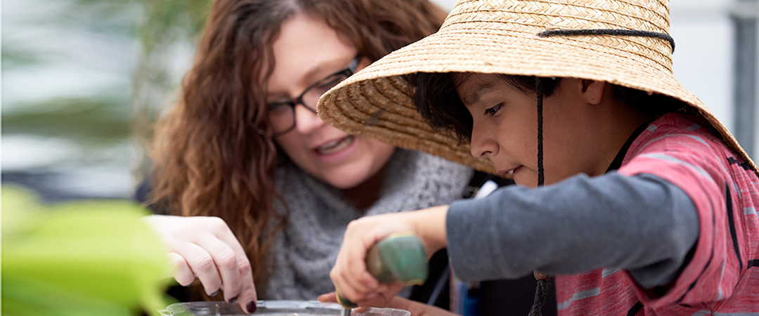 Boy and a recreation therapist working in the garden.