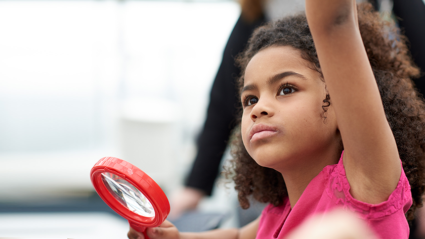 Young girl raising her hand during recreation therapy.
