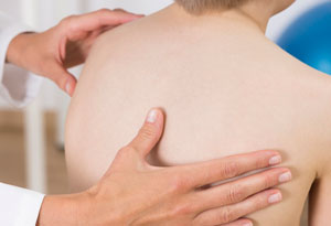 Doctor exams a patient's back.